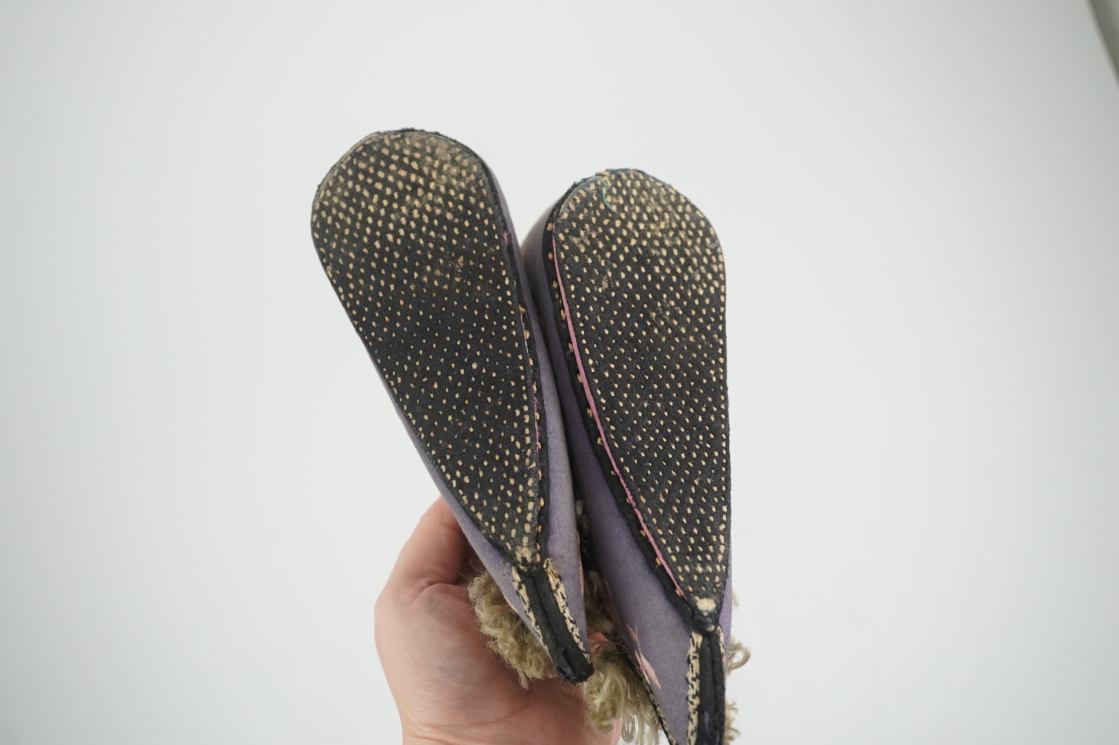 Three pairs of late 19th / early 20th century Chinese ladies embroidered silk shoes, for bound feet, one with sheep’s wool pom-poms, together with a similar a pair of silk embroidered ankle boots and pair of decorative r